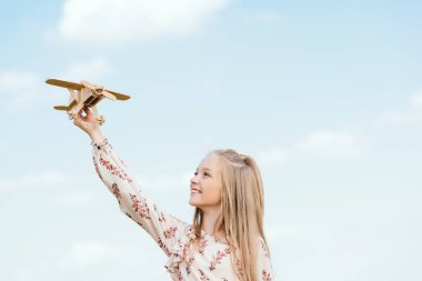 oyuncak uçak önünde mavi gökyüzü ile oynayan güzel küçük çocuk