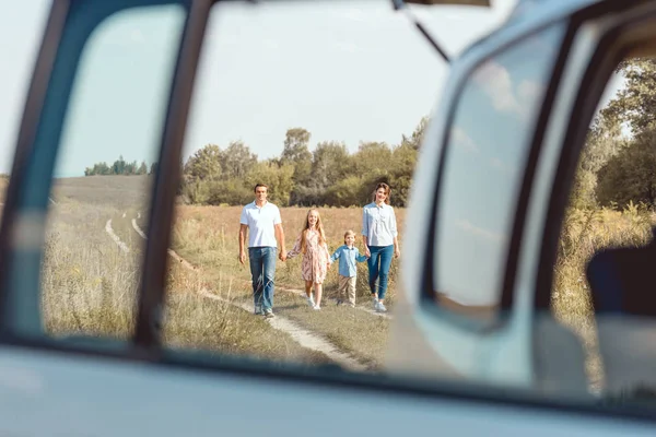 Feliz Jovem Família Mãos Dadas Andando Carro Por Campo — Fotografia de Stock