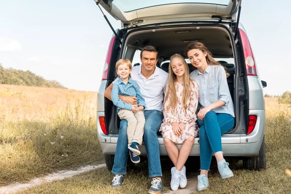 Happy Young Family Sitting Car Trunk Looking Camera Field — Stock Photo, Image