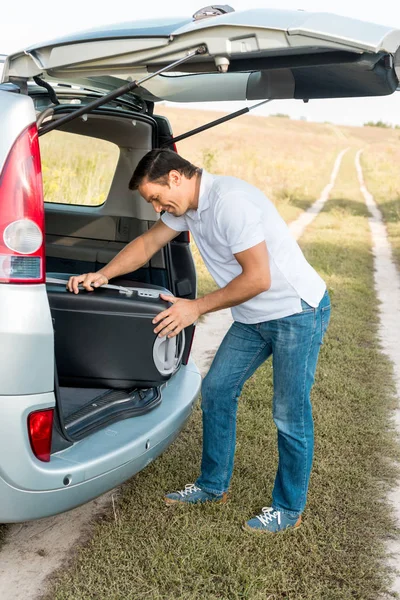 Gelukkig Man Verpakking Koffer Bagage Kofferbak Van Auto Veld — Gratis stockfoto