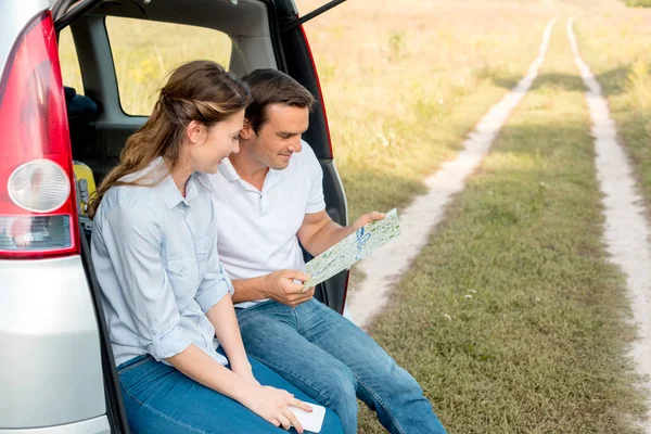Smiling Adult Couple Sitting Car Trunk Looking Map While Having — Stock Photo, Image