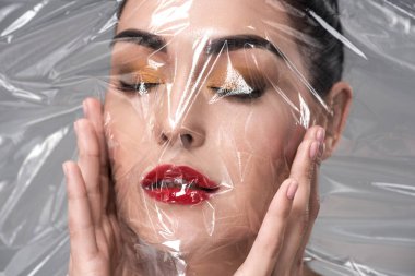 güzel genç kadın kapalı gözler saydam maske gri holding ile