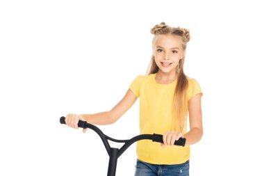 Scooter tutarak ve üzerinde beyaz izole kamera gülümseyen güzel mutlu çocuk