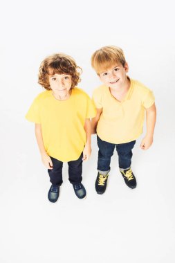 high angle view of two happy boys standing together and smiling at camera isolated on white clipart