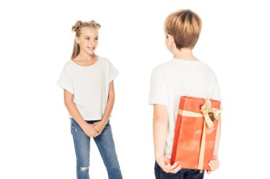 boy hiding gift box behind back to present to friend isolated on white clipart