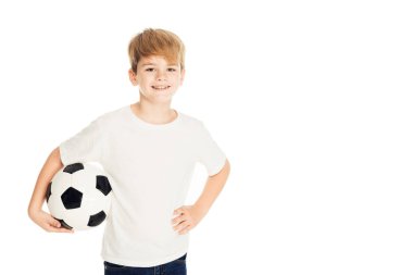 futbol topu tutarak ve üzerinde beyaz izole kamera bakarak gülümseyen sevimli çocuk