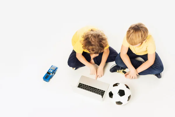 Вид Сверху Двух Маленьких Мальчиков Помощью Ноутбука Сидя Игрушками Изолированными — стоковое фото