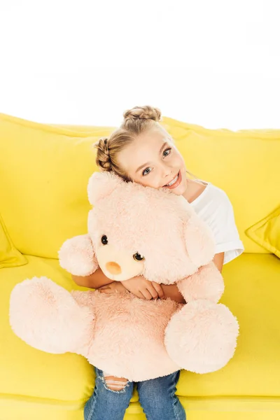 Sorrindo Adorável Criança Abraçando Ursinho Sofá Amarelo Isolado Branco Olhando — Fotos gratuitas
