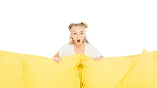 Impactado Adorable Niño Mirando Hacia Fuera Desde Sofá Amarillo Aislado — Foto de stock gratis