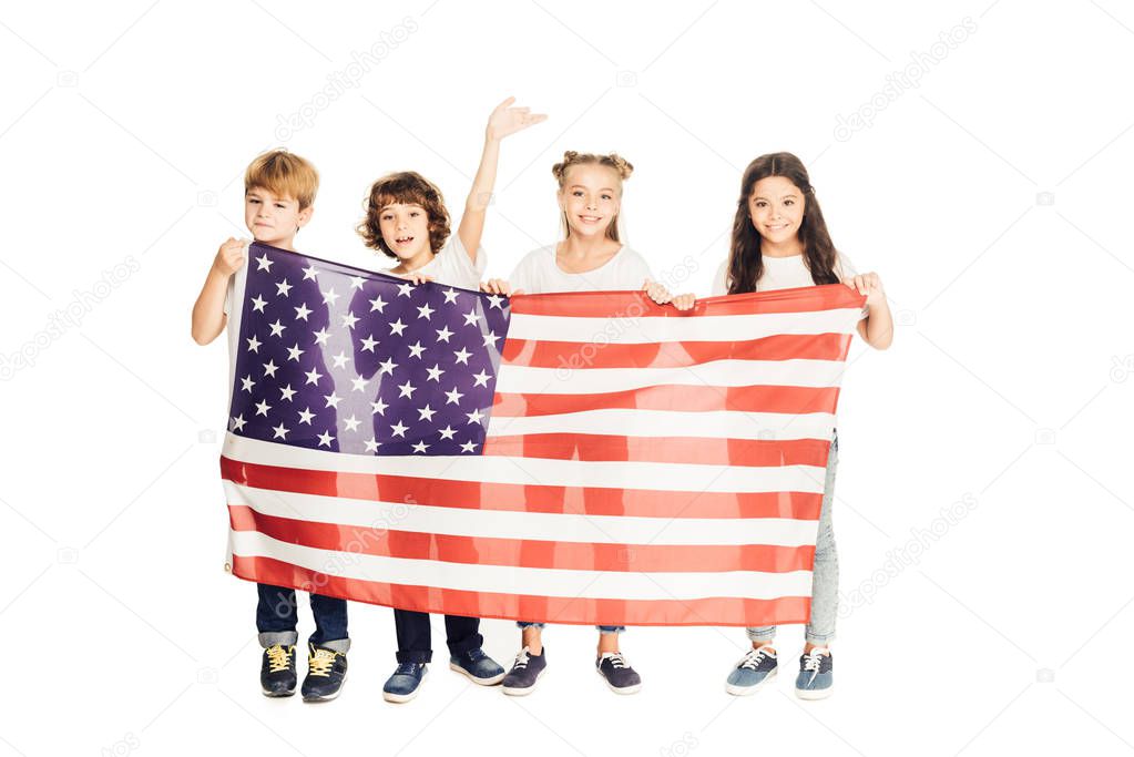 smiling adorable kids holding american flag and looking at camera isolated on white