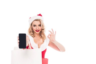 Noel Baba kız ile ok işareti yapıyor ve smartphone ile boş ekran üzerinde beyaz izole gösteren poşetler
