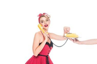 young pin up woman dialing phone number of retro telephone on serving tray in male hand isolated on white clipart