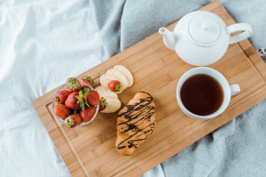 lezzetli breakfast üstten görünüm yatakta ahşap tepsi 