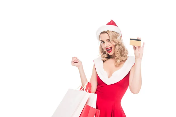 欢快的圣诞老人女孩在圣诞礼服举行购物袋和显示信用卡孤立的白色 — 图库照片