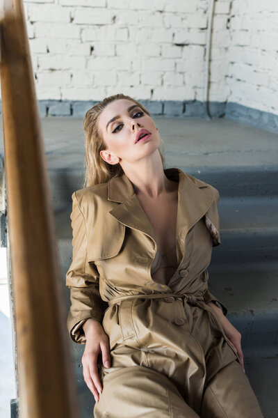 portrait of fashionable young woman on stairs looking at camera