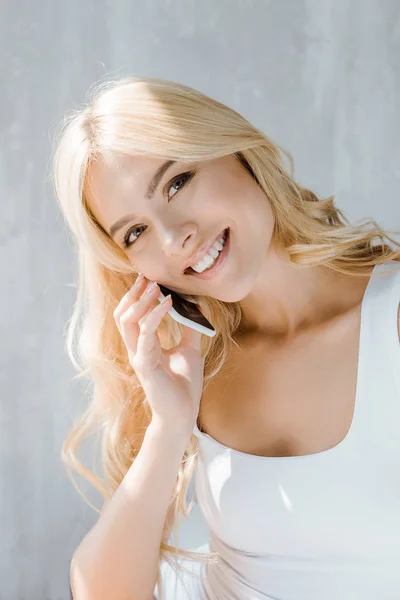 Hermosa Chica Rubia Feliz Hablando Por Teléfono Inteligente Sonriendo Cámara — Foto de Stock