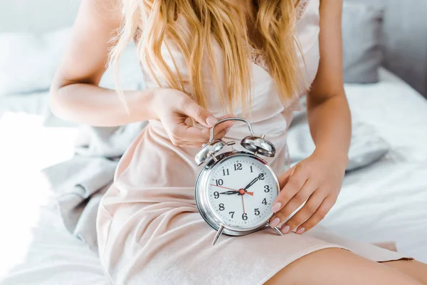 Recortado Disparo Joven Rubia Sentada Cama Celebración Reloj Despertador — Foto de Stock