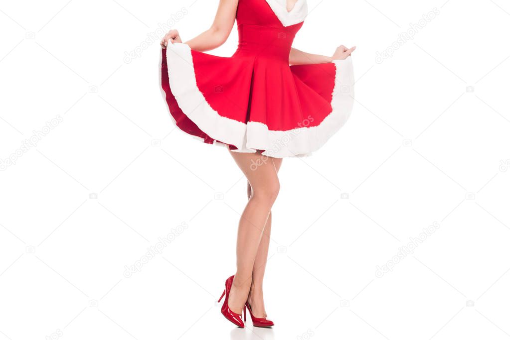 cropped image of sexy santa girl in high heels raising up christmas dress isolated on white