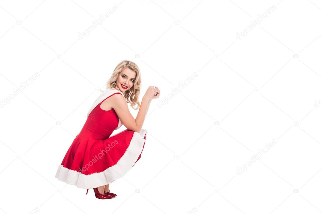 happy attractive santa girl in christmas dress sitting isolated on white 