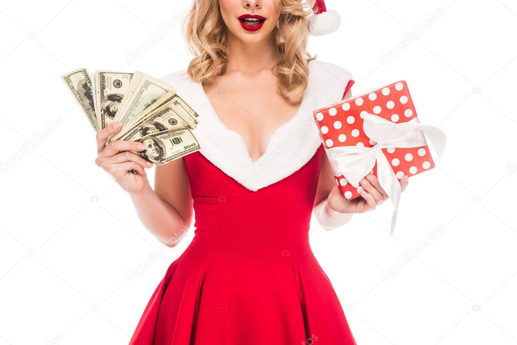 partial view of santa girl in christmas hat holding cash money and gift box isolated on white