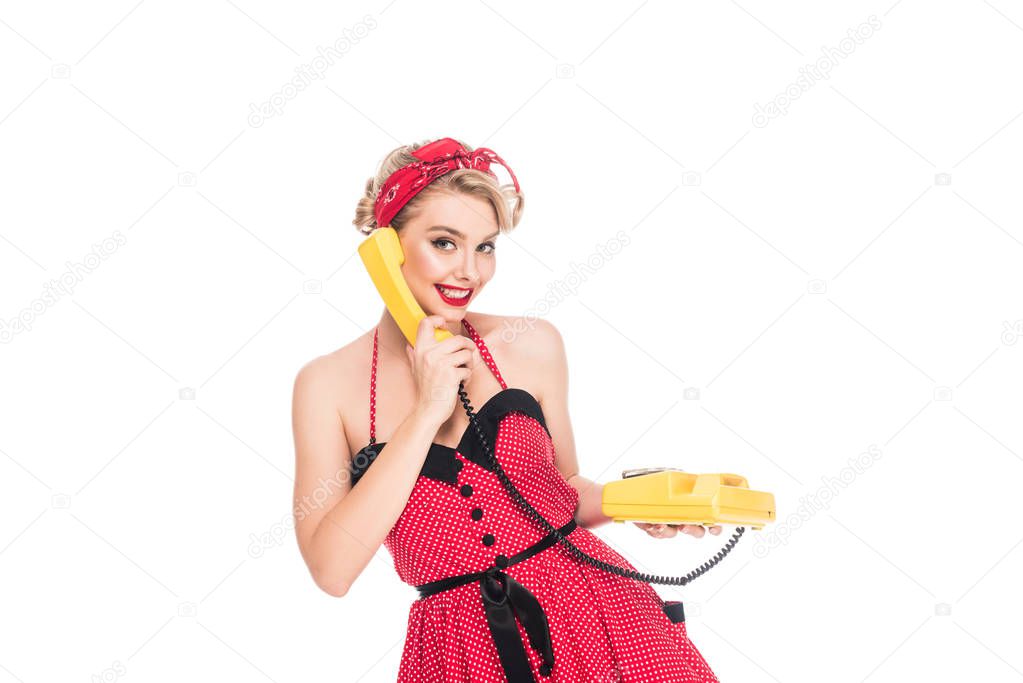 portrait of pretty woman in pin up dress talking on retro telephone isolated on white