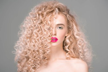 portrait of beautiful naked young woman with long curly hair looking at camera isolated on grey clipart
