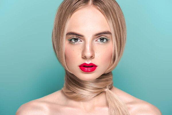 портрет красивой молодой голой женщины с длинными волосами вокруг шеи, смотрящей на камеру, изолированную на голубом
