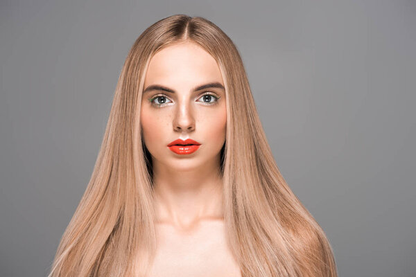 красивая молодая голая женщина с длинными волосами, смотрящая на камеру, изолированную от серого

