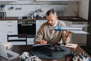 roket modeli tutarak ve notlar evde yakışıklı mühendisi