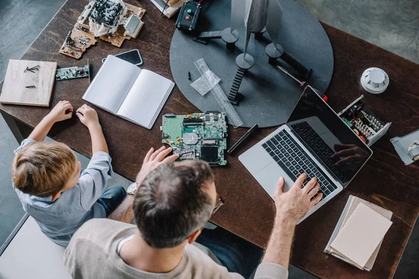 Overhead View Father Son Using Laptop Modeling Rocket Home — Stock Photo, Image