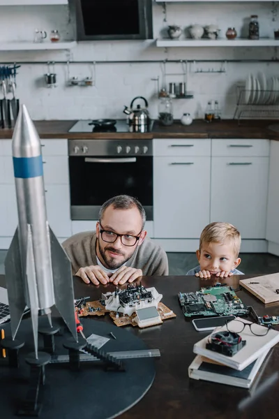 Vader Zoon Uit Tabel Keuken Kijken Naar Model Van Rocket — Stockfoto