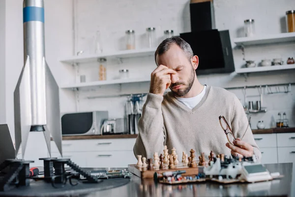 Tired Handsome Man Playing Chess Touching Nose Bridge Home — Free Stock Photo