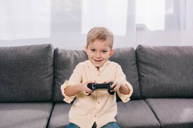 Joystick ile evde oynarken mutlu küçük çocuk