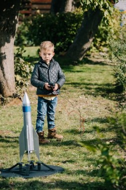 cute little boy launching model rocket outdoor  clipart