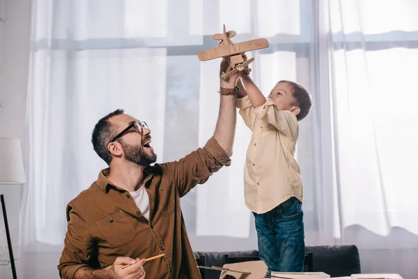 Счастливый Отец Маленький Сын Играют Деревянный Игрушечный Самолет Моделируя Вместе — стоковое фото
