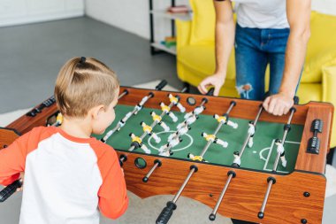 Baba ve oğul birlikte evde masa futbolu oynayan kısmi görünümünü