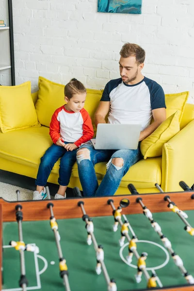 Father Son Using Laptop Together While Resting Yellow Sofa Home — Free Stock Photo