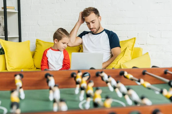 Selective Focus Father Son Using Laptop Together While Resting Yellow — Free Stock Photo