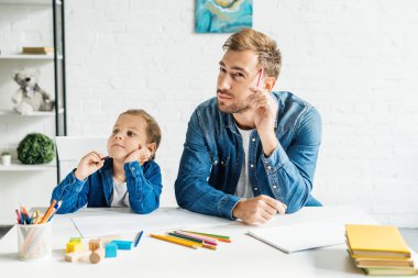 düşünceli genç baba evde küçük oğlu ile çizim