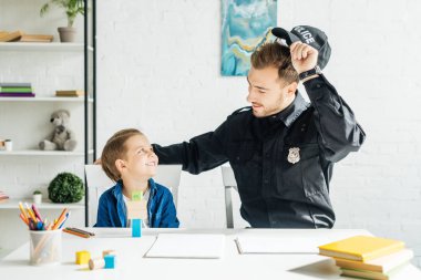 Polis üniforması genç baba ve oğul evde birlikte vakit gülümseyen