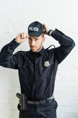 kap beyaz tuğla duvar önünde koyarak çekici genç polis memuru