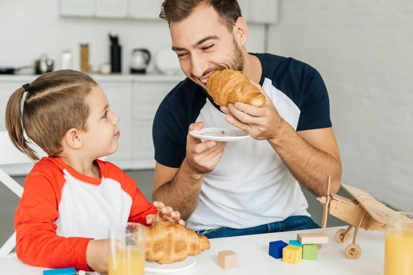 Šťastný Mladý Otec Syn Snídaně Croissanty Džusem Společně Doma — Stock fotografie