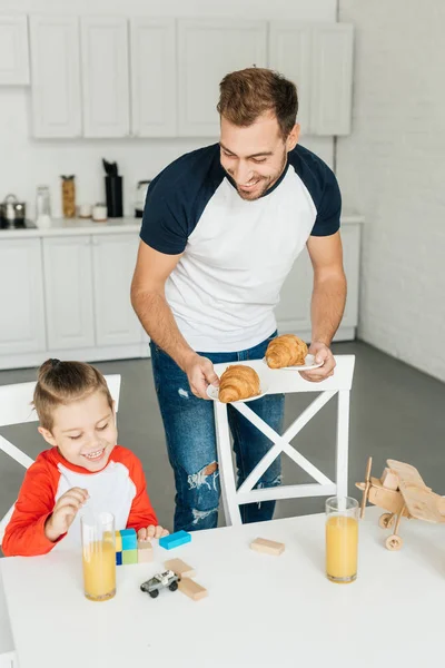 Pohledný Mladý Otec Syn Croissanty Snídani Doma — Stock fotografie zdarma