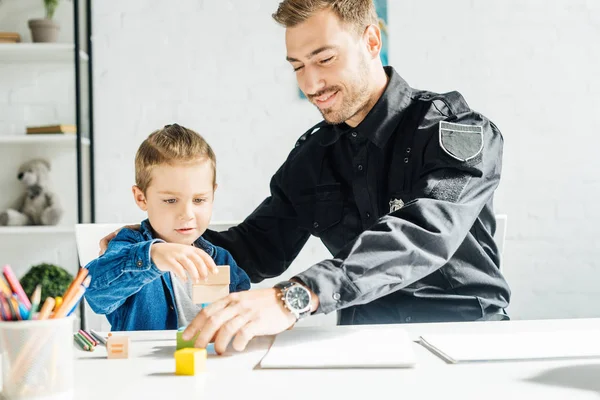 Šťastný Mladý Otec Policejní Uniformě Syn Spolu Hrají Doma — Stock fotografie