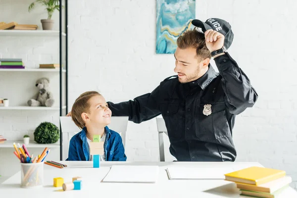 Lächelnder Junger Vater Polizeiuniform Und Sohn Verbringen Zeit Miteinander Hause — Stockfoto