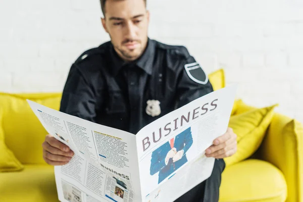 Handsome Young Policeman Reading Newspaper Couch — Free Stock Photo