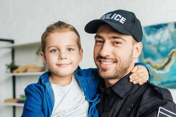 Mutlu Genç Baba Küçük Oğlunu Taşıyan Kameraya Bakarak Polis Üniforması — Stok fotoğraf