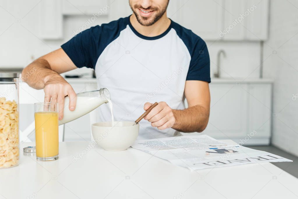 partial view of man having breakfast in kitchen at home