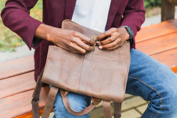 Cropped Shot Student Opening Leather Backpack While Sitting Bench Street — Free Stock Photo