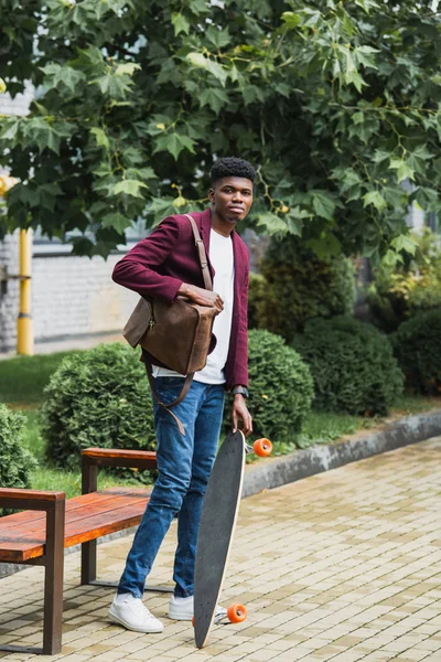 Joven Estudiante Guapo Con Mochila Monopatín Pie Calle — Foto de stock gratis